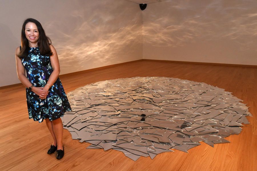 Jennifer Reynolds-Kaye, the new director of the Housatonic Museum of Art, poses inside the Chernow Galleries next to installations currently on display by Stamford artist June Ahrens, in Bridgeport, Conn. Sept. 8, 2022.