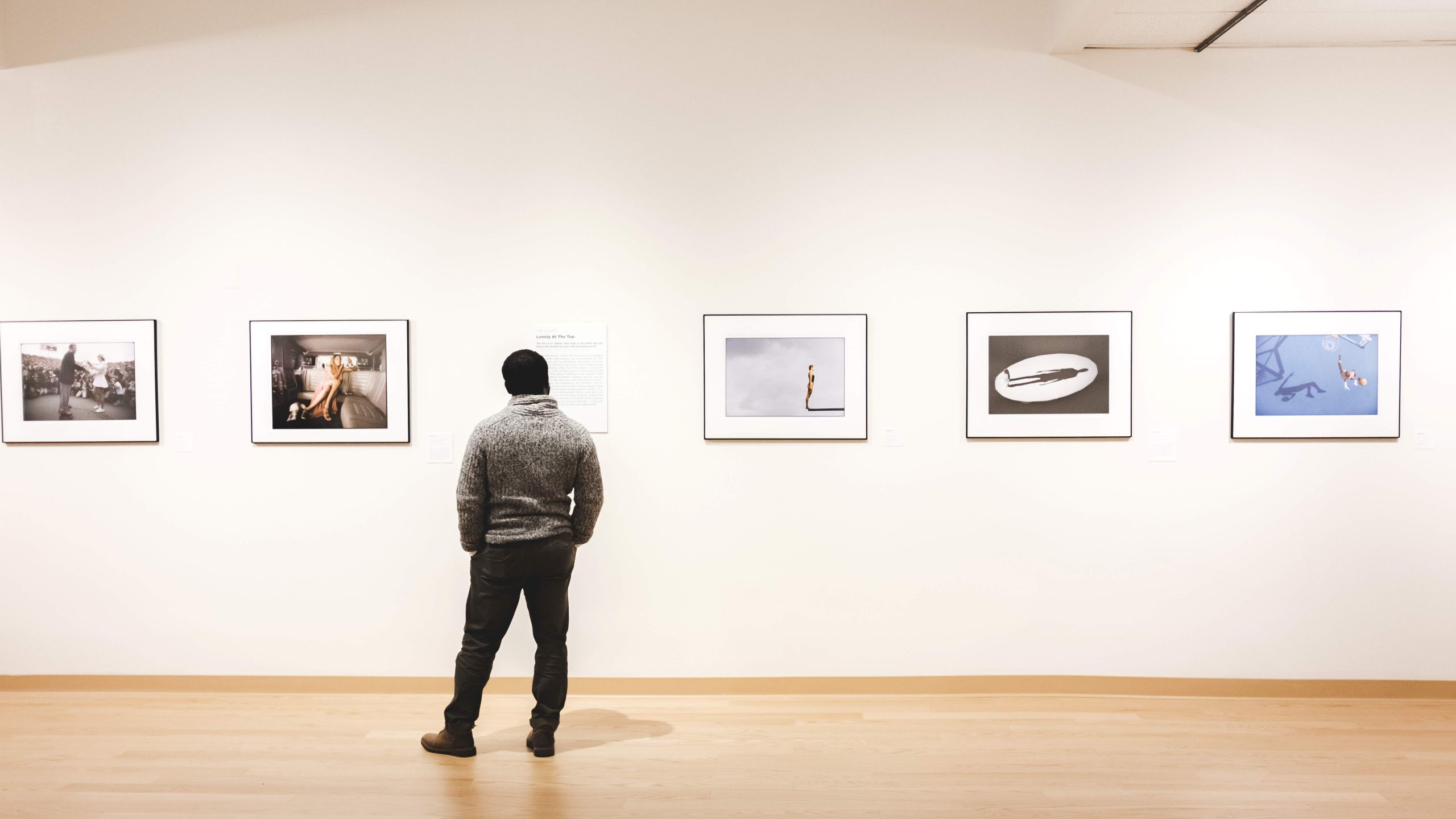 Installation shot of person and 5 photographs