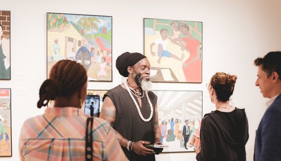 Iyaba Ibo Mandingo speaking with visitors in exhibition. Photography by Brandon Smith, Whiskey & Oxfords