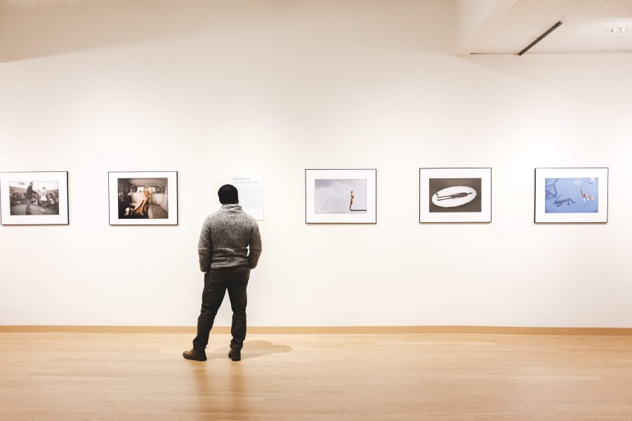 Installation shot of person and 5 photographs