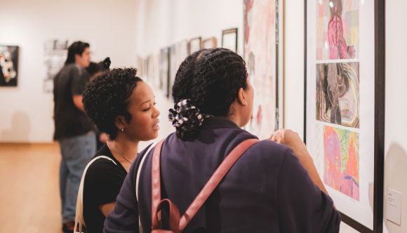 Two students looking at artwork